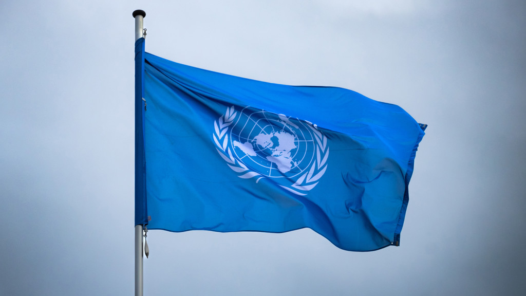 Kuvassa YK:n lippu taivasta vasten.